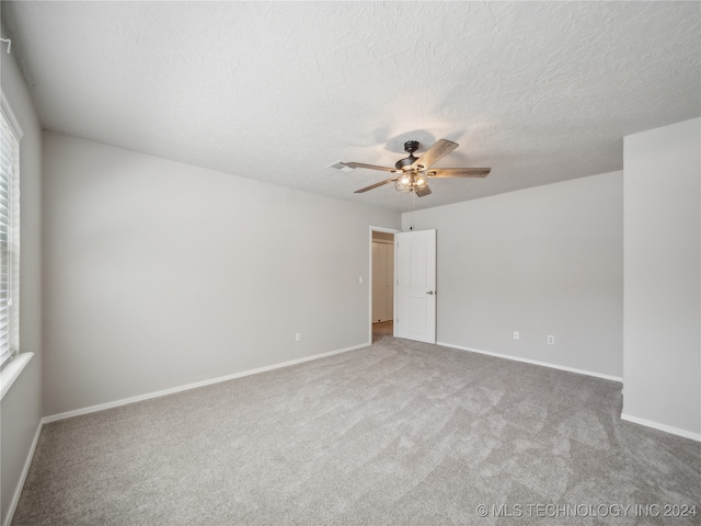 carpeted empty room with ceiling fan and a textured ceiling