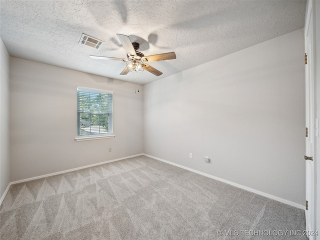 carpeted empty room featuring a textured ceiling