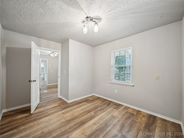 empty room featuring hardwood / wood-style floors and a textured ceiling