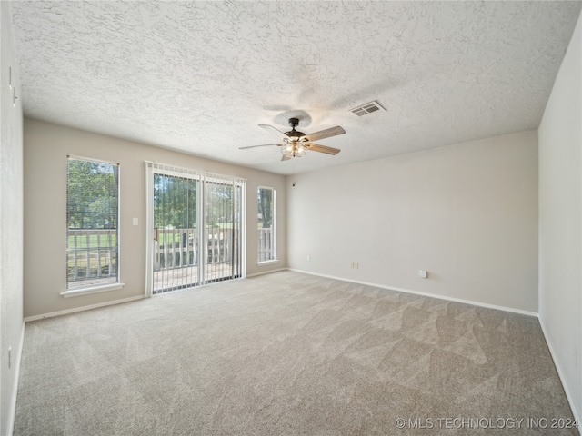 carpeted spare room with ceiling fan and a textured ceiling