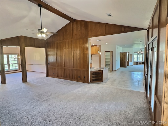 interior space with ceiling fan, high vaulted ceiling, wooden walls, and beam ceiling