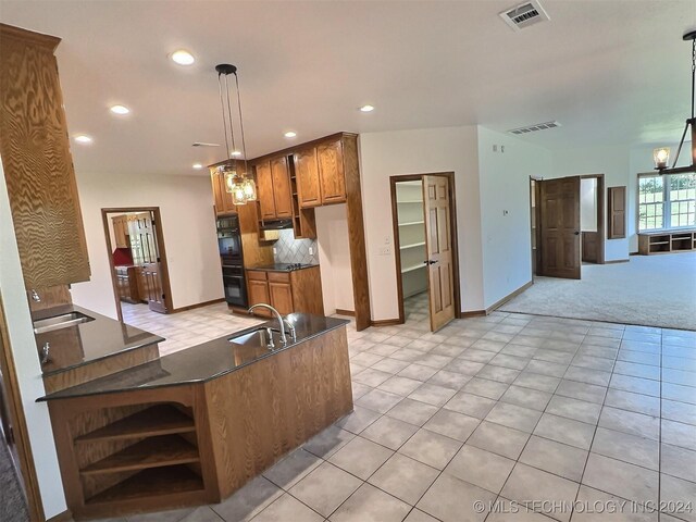 kitchen with decorative backsplash, sink, hanging light fixtures, and light carpet