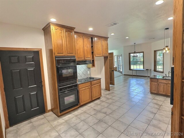 kitchen featuring an inviting chandelier, range hood, light tile patterned floors, decorative backsplash, and decorative light fixtures