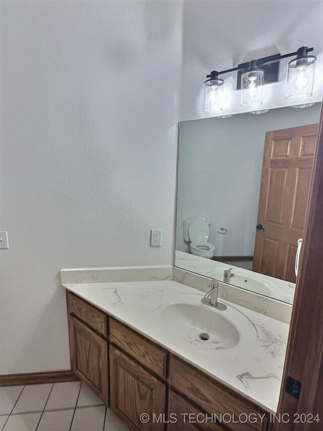 bathroom featuring tile patterned floors, vanity, and toilet