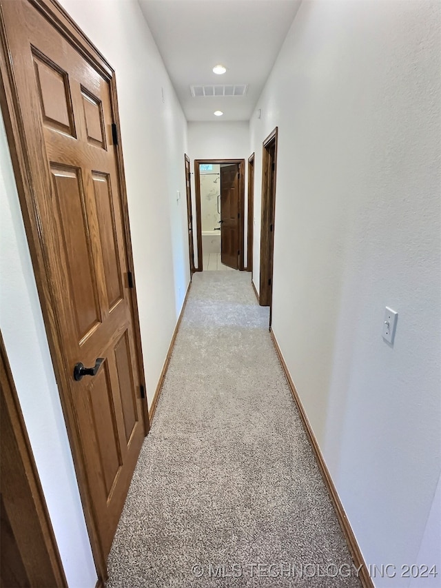 hall with light colored carpet