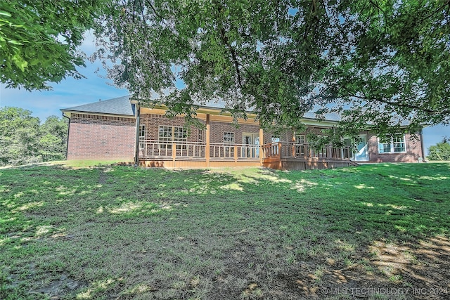 back of house with a wooden deck and a lawn