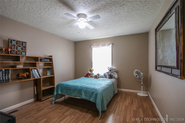 bedroom with a textured ceiling, wood-type flooring, and ceiling fan