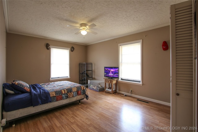 bedroom featuring crown molding, ceiling fan, hardwood / wood-style floors, and a textured ceiling