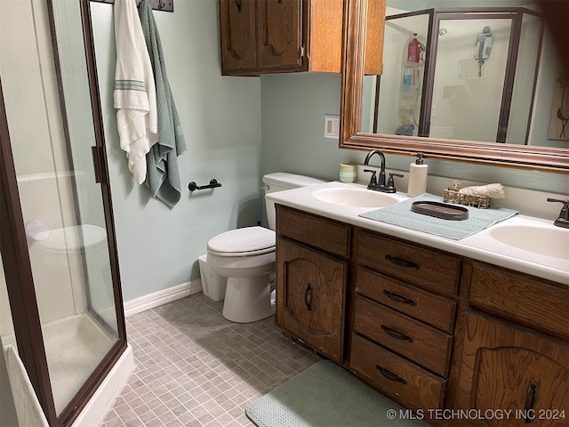 bathroom featuring vanity, toilet, and a shower with door