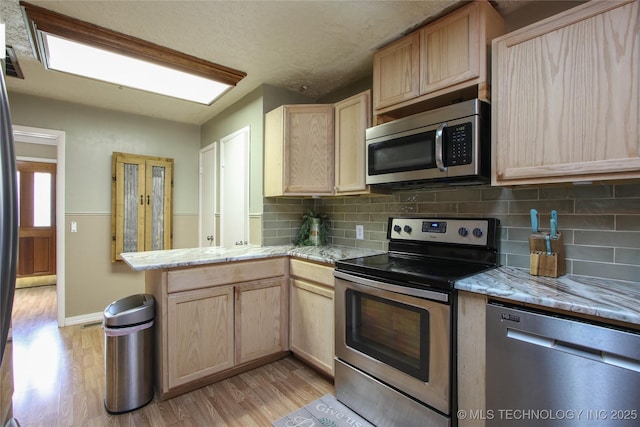 kitchen featuring stainless steel appliances, light hardwood / wood-style floors, and light brown cabinets