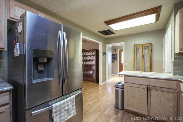 kitchen featuring light brown cabinets, light hardwood / wood-style floors, and stainless steel fridge with ice dispenser