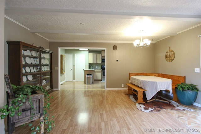 dining area with an inviting chandelier, ornamental molding, and light wood-type flooring