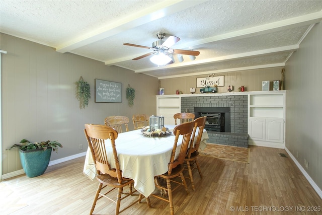 dining space with beamed ceiling, hardwood / wood-style flooring, and a textured ceiling