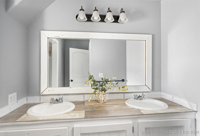 bathroom with vanity and lofted ceiling