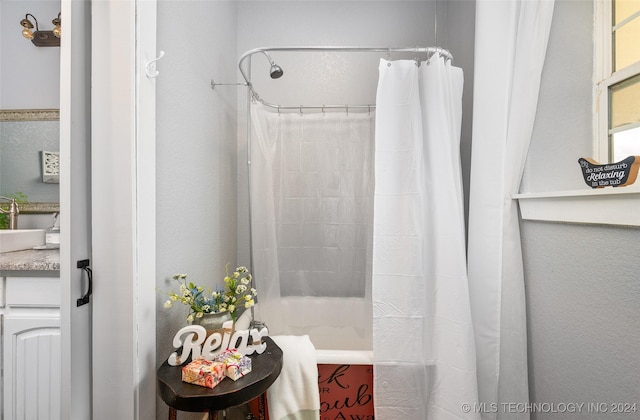 bathroom with vanity and shower / bathtub combination with curtain