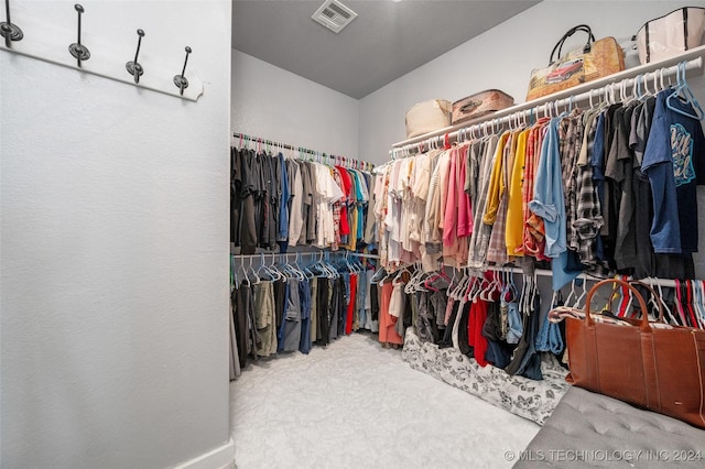 walk in closet with carpet flooring