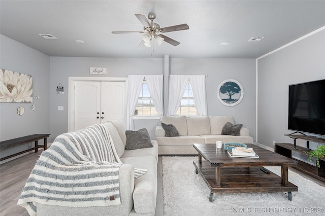 living room featuring a textured ceiling, light hardwood / wood-style flooring, and ceiling fan