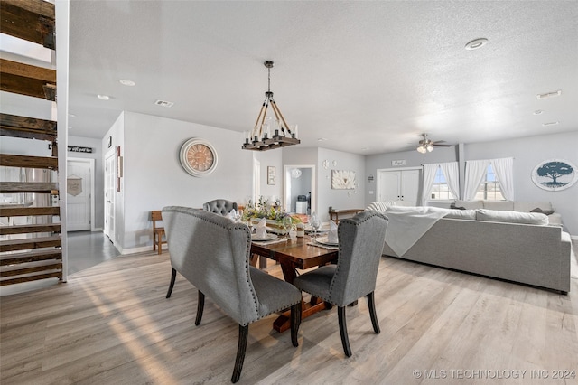 dining area featuring ceiling fan with notable chandelier, a textured ceiling, and light hardwood / wood-style floors