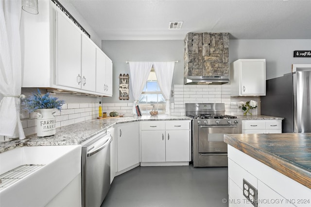 kitchen featuring stainless steel appliances, white cabinetry, and tasteful backsplash