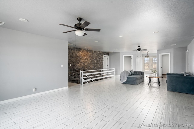 interior space with ceiling fan, a textured ceiling, and light hardwood / wood-style flooring