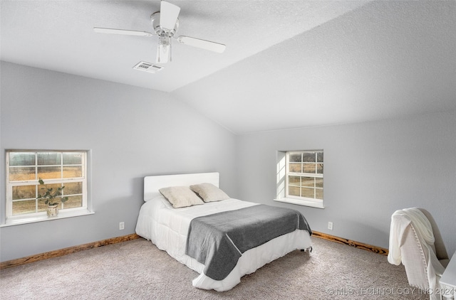 bedroom featuring ceiling fan, carpet floors, vaulted ceiling, and multiple windows