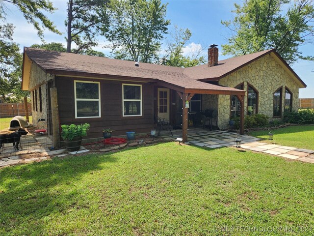 ranch-style home featuring a front lawn and a patio