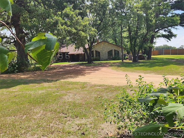 view of yard with driveway and fence