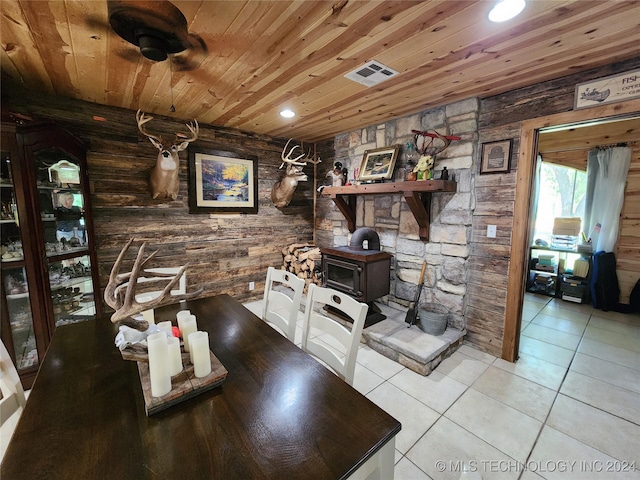 dining space featuring recessed lighting, visible vents, a wood stove, light tile patterned flooring, and wooden ceiling