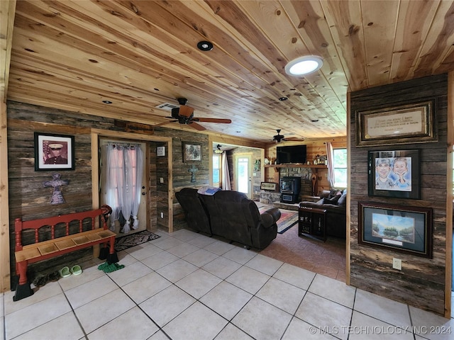 living area featuring wood ceiling, a fireplace, wooden walls, and light tile patterned floors