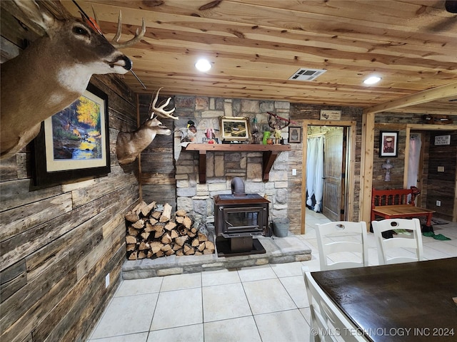 living area featuring light tile patterned floors, recessed lighting, wood ceiling, visible vents, and a wood stove