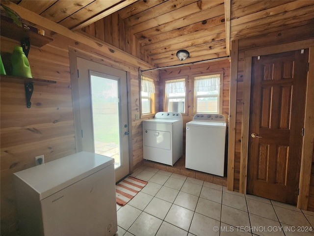 washroom featuring laundry area, light tile patterned floors, wood ceiling, wood walls, and separate washer and dryer