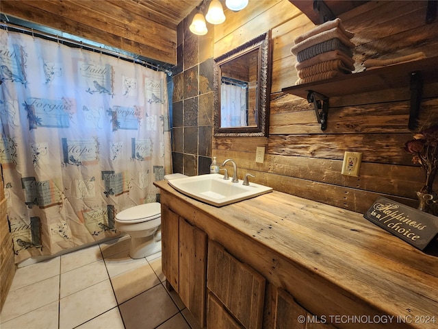 full bath featuring wooden walls, vanity, toilet, and tile patterned floors