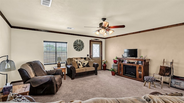 carpeted living room with ceiling fan and ornamental molding