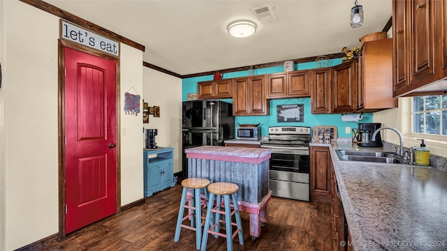 kitchen featuring dark hardwood / wood-style floors, sink, a kitchen bar, and stainless steel appliances