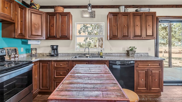 kitchen featuring pendant lighting, stainless steel range with electric cooktop, sink, light stone countertops, and black dishwasher