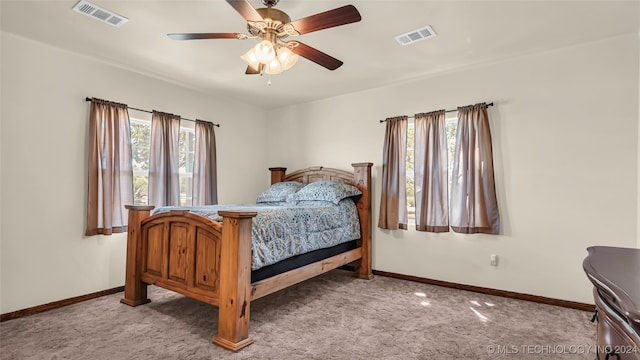 carpeted bedroom with multiple windows and ceiling fan