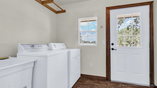 washroom with dark hardwood / wood-style floors, washing machine and dryer, and sink