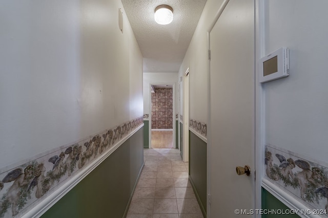 hallway with light tile patterned flooring and a textured ceiling