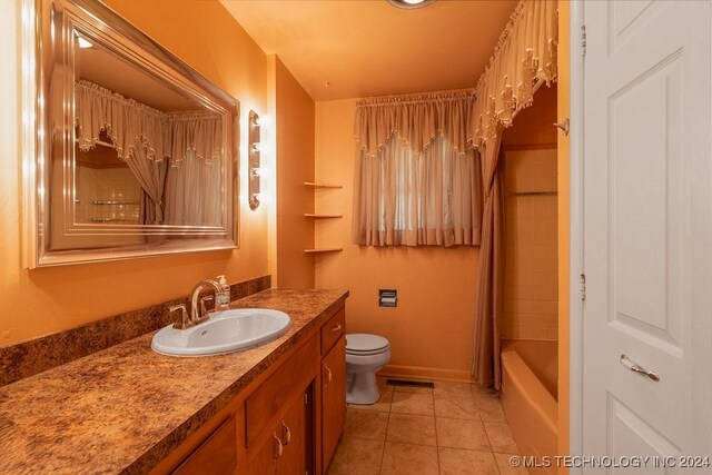 full bathroom with tile patterned floors, shower / tub combo, vanity, and toilet