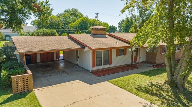 ranch-style home with a front yard and a carport