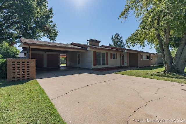 ranch-style home featuring a carport and a front lawn