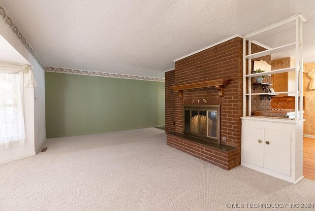 unfurnished living room featuring a fireplace, a textured ceiling, and light colored carpet