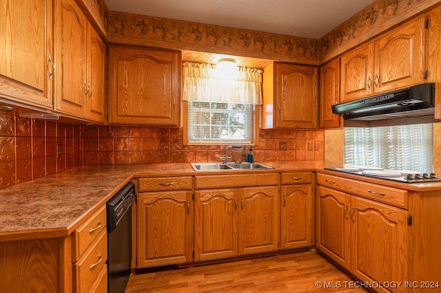 kitchen featuring black dishwasher, sink, tasteful backsplash, light hardwood / wood-style floors, and gas stovetop