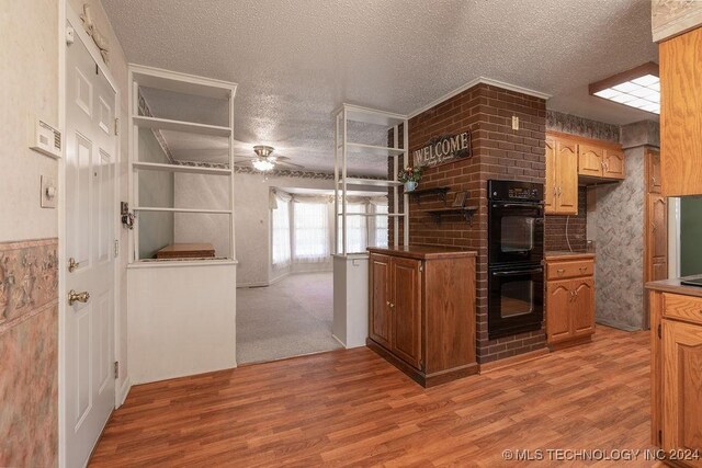 kitchen with a textured ceiling, double oven, carpet flooring, and ceiling fan