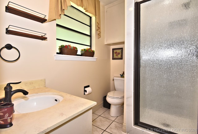 bathroom featuring vanity, toilet, an enclosed shower, and tile patterned floors