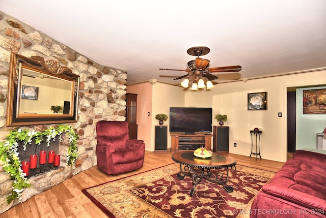 living room featuring ornamental molding, a fireplace, ceiling fan, and light hardwood / wood-style floors