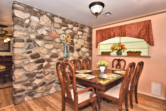 dining room with a textured ceiling and wood-type flooring