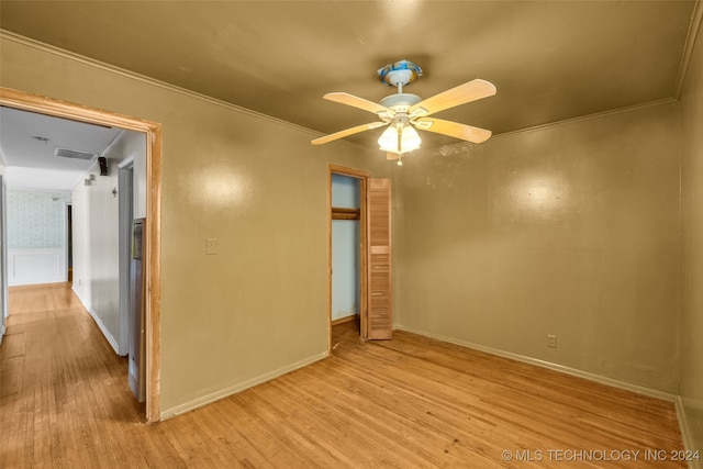 unfurnished bedroom featuring light hardwood / wood-style flooring, ceiling fan, ornamental molding, and a closet