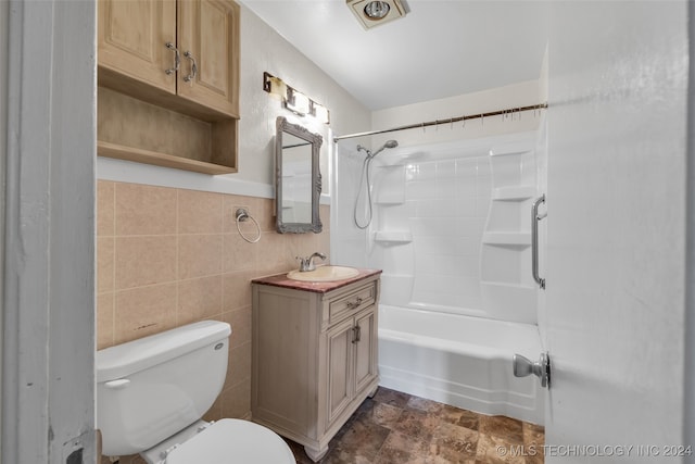 full bathroom featuring toilet, tile patterned flooring, vanity, tile walls, and shower / washtub combination