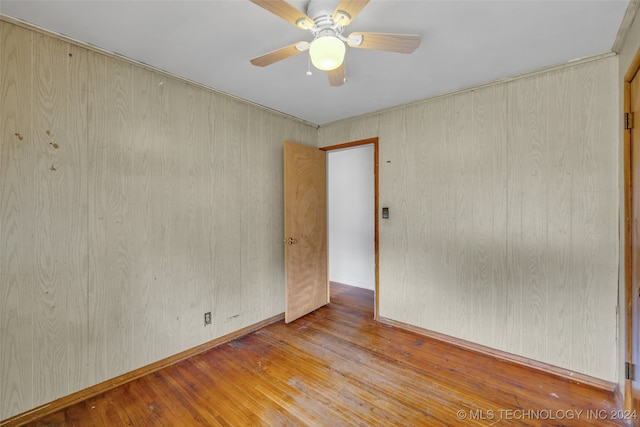 empty room with ceiling fan and light hardwood / wood-style flooring